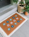 The Letterfolk Clay Tile Mat displayed on a front porch.