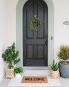 The Letterfolk Clay Tile Mat used in a beautiful front porch setting.