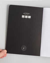 Composition Book in Black on a themed background