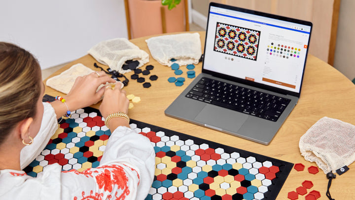 A woman using the Letterfolk design tool to design a tile mat. 