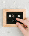 A hand assembling letters on the Letterfolk Ornament Letter Board.