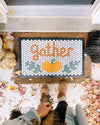 The Gather Round November Design of the Month on a tile mat in a doorway