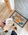 The Gather Round November Design of the Month on a tile mat in a doorway