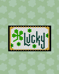 The Letterfolk St Patrick's Tile Set on a White Tile Mat on a green background. 