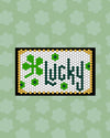 The Letterfolk St Patrick's Tile Set on a White Tile Mat on a green background. 