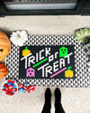 The Letterfolk "Trick or Treat" Black Tile Mat used in a Halloween display on a front porch.