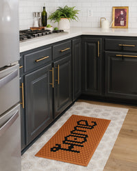 The Letterfolk " HOME" Clay Tile Mat set in a kitchen.