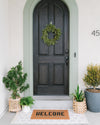 The Letterfolk Clay Tile Mat used in a beautiful front porch setting. 