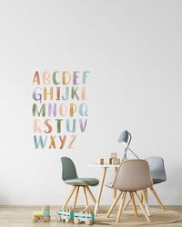 The Wall Decals in Watercolor Letters pasted on a wall in a kids room.