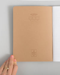 Composition Book in Kraft on a themed background